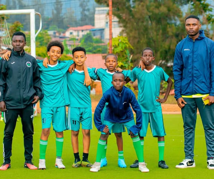 ISA youth team with coaches on the pitch in Kigali
