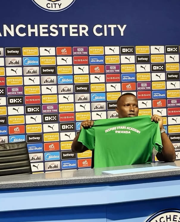 Inspire Stars Academy at Manchester City — holding the ISA jersey in the Etihad Stadium press room